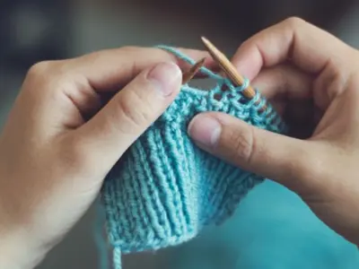 Hands knitting a patch