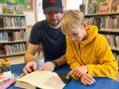 Father and son reading a book using an ereader
