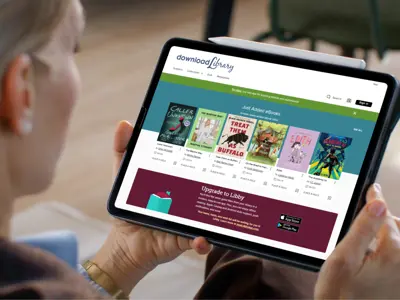 Woman looking at downloadLibrary homepage on her tablet device