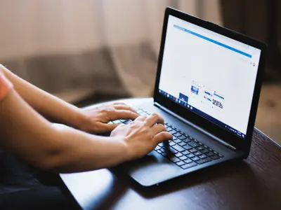 Hands typing on a laptop
